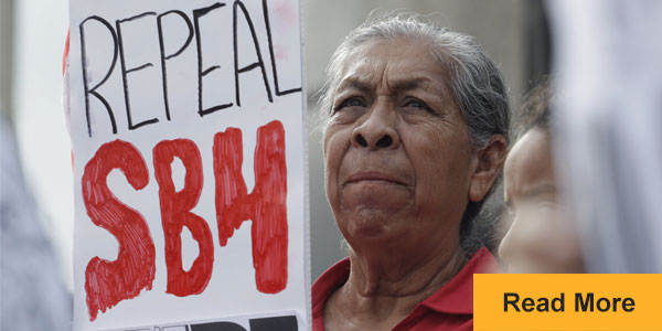 Woman holding sign: Repeal SB4