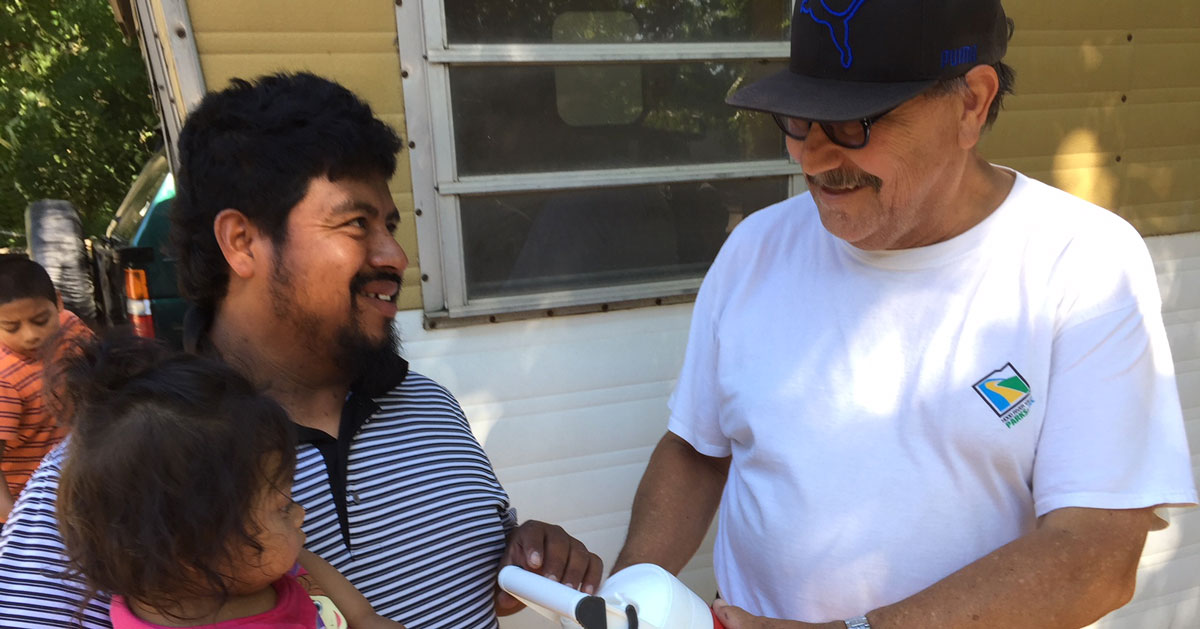 Joel Pelayo giving water cooler to migrant worker