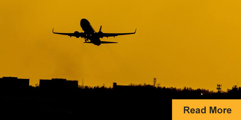 Airplane taking off at sunset