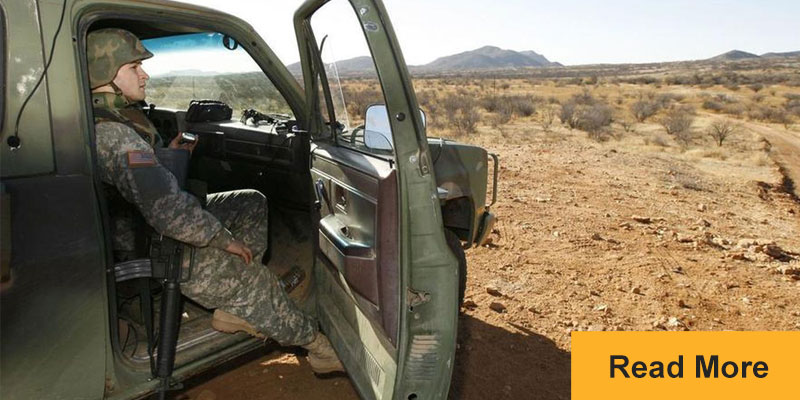 Border guard with assault rifle sitting in truck