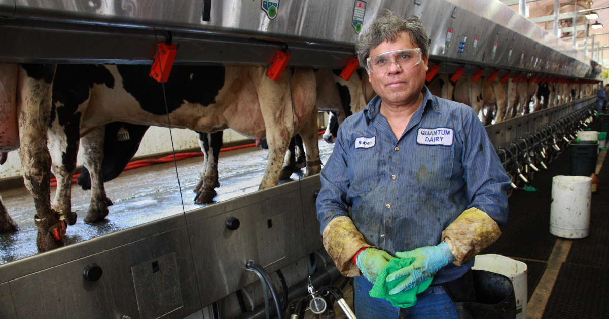 dairyworker poses in front of machine