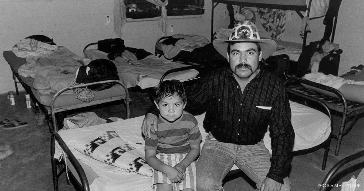 father and son sit in room surrounded by other beds