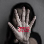 Woman holding up hand with the word 'STOP' written on it