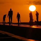 Workers in the field at sunset