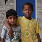 two children standing in front of a brick building