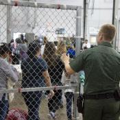 CBP officer lets detainees out of holding area.