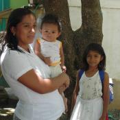 Woman stands with her baby and daughter