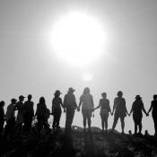 People standing together on hillside under sun