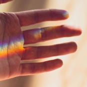 hand outstretched with rainbow light