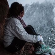 migrant woman looking out over snow covered forest