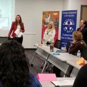 Woman speaking to audience in front of presentation screen