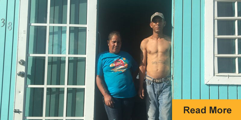 Man and woman standing in doorway looking straight ahead