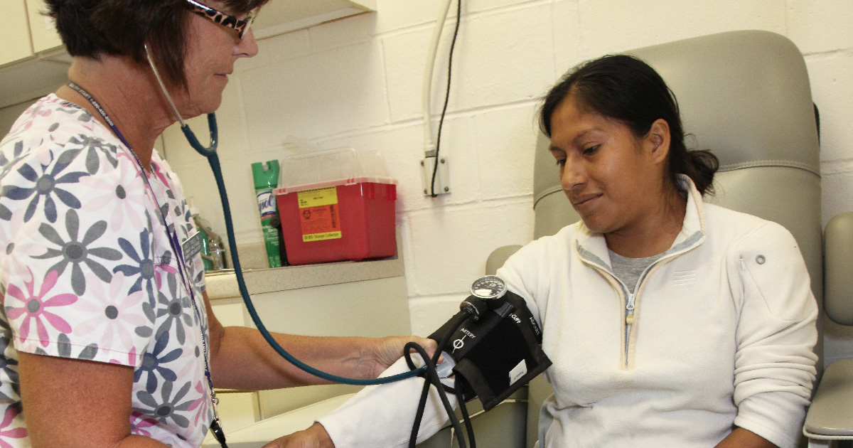 Nurse checks blood pressure of patient