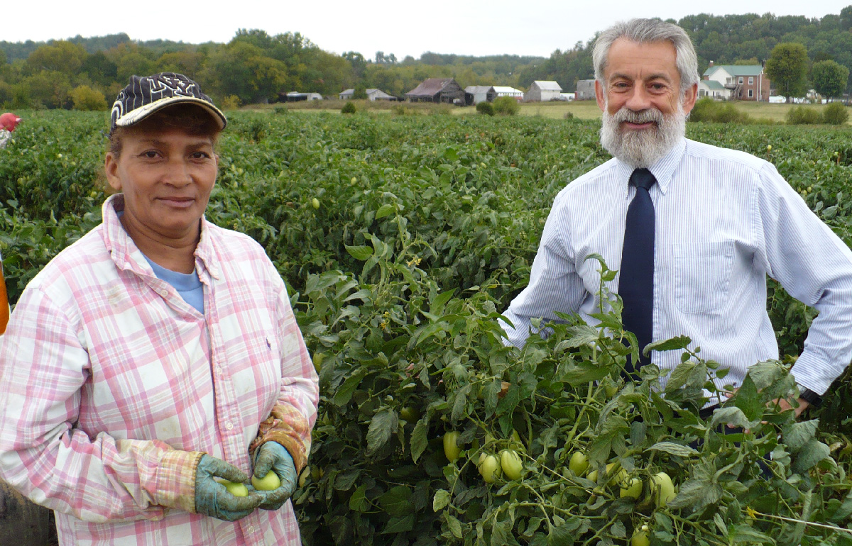 Ed Zuroweste in field with farmworker