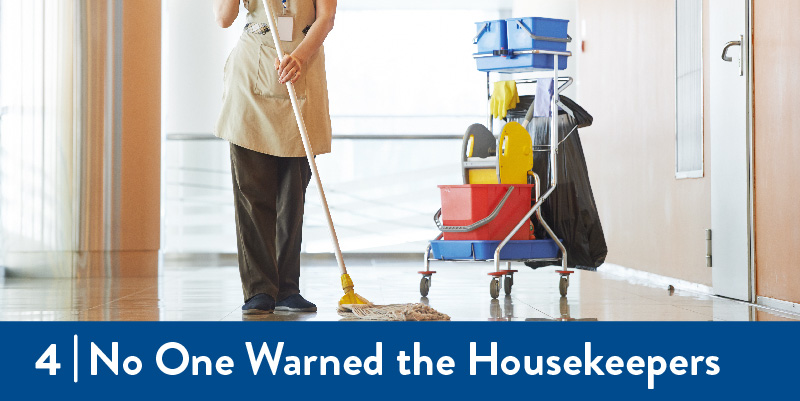 A photo of a custodian mopping the floor of a commercial building