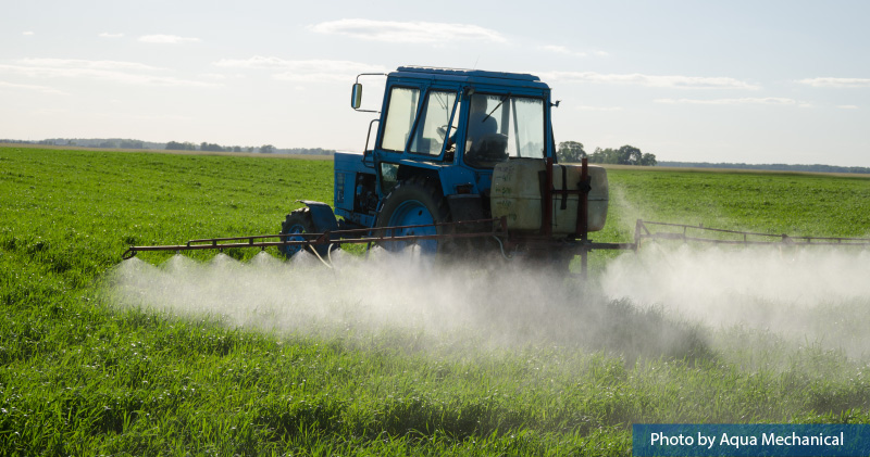 A vehicle spraying pesticides on a field