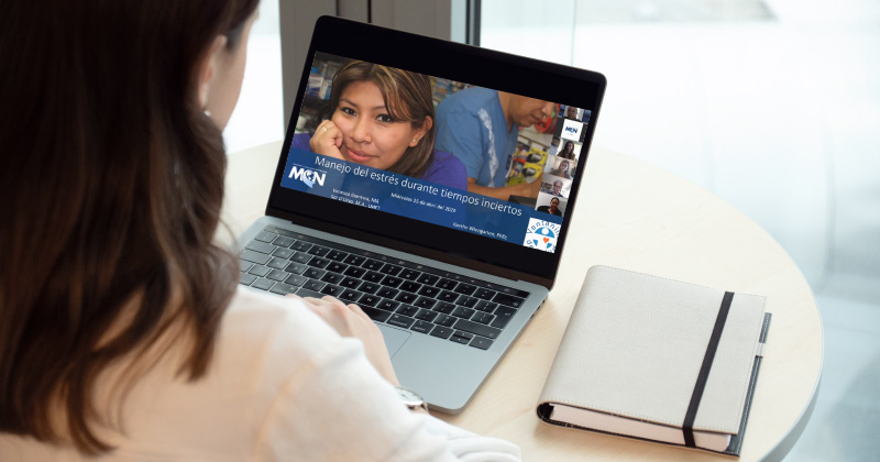 A woman watching a webinar on her laptop