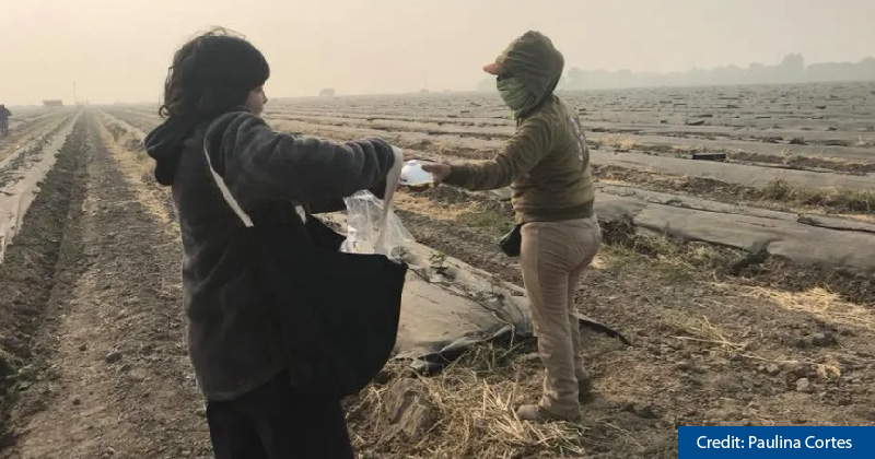 Paulina Cortes, a community activist from San Jose, gives a protective particulate mask to a farmworker in Stockton, California, on November 16th, 2018.