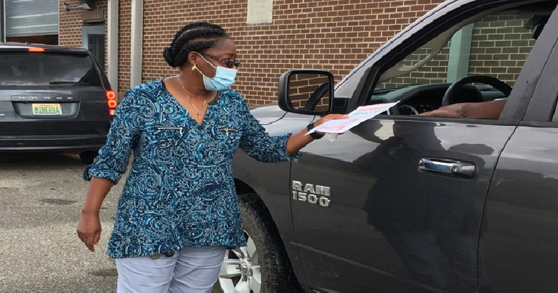 Clinician speaks with person in car