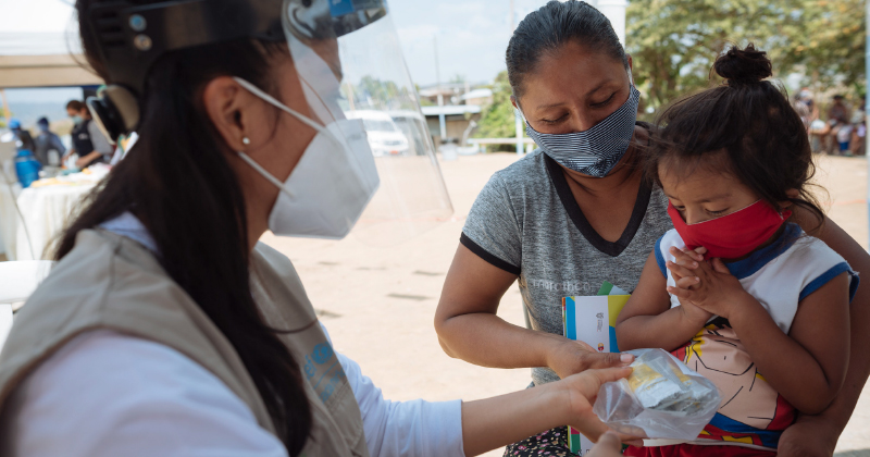 A mother and child receive supplies from clinician