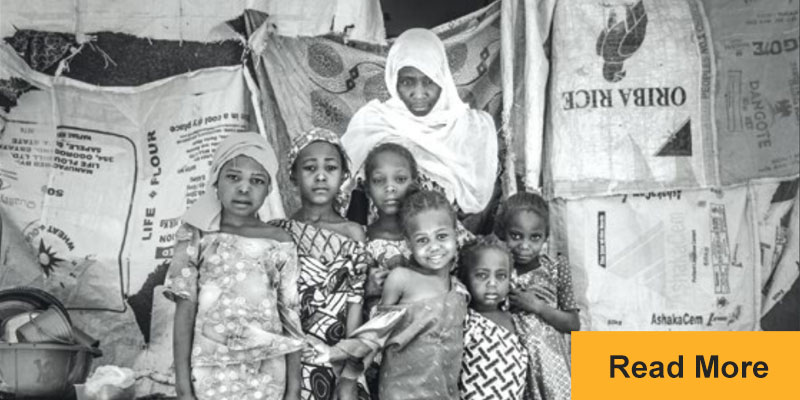 mother and children standing outside tent