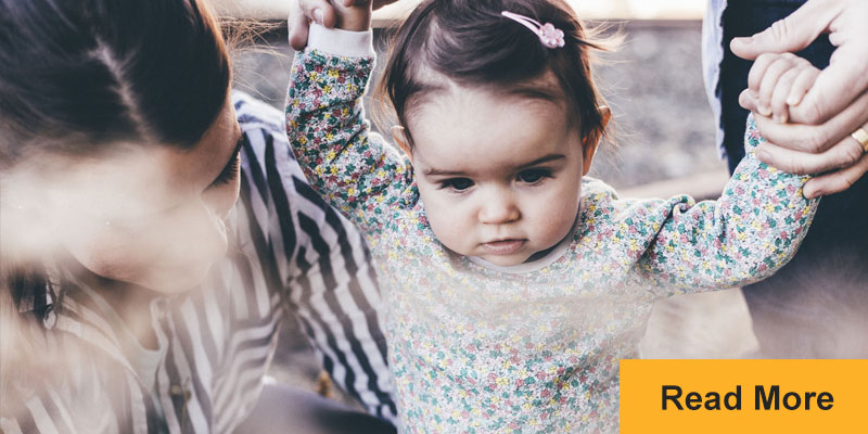 toddler walking with parents