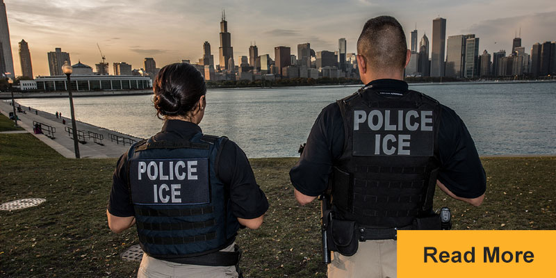 Two ICE police officers looking at cityscape