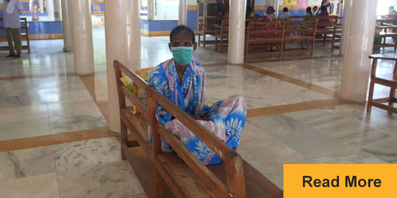 woman sitting on bench with face mask