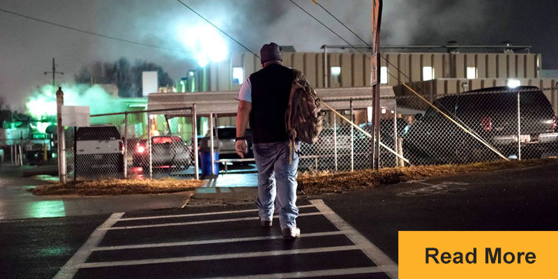 Worker walking across street to factory